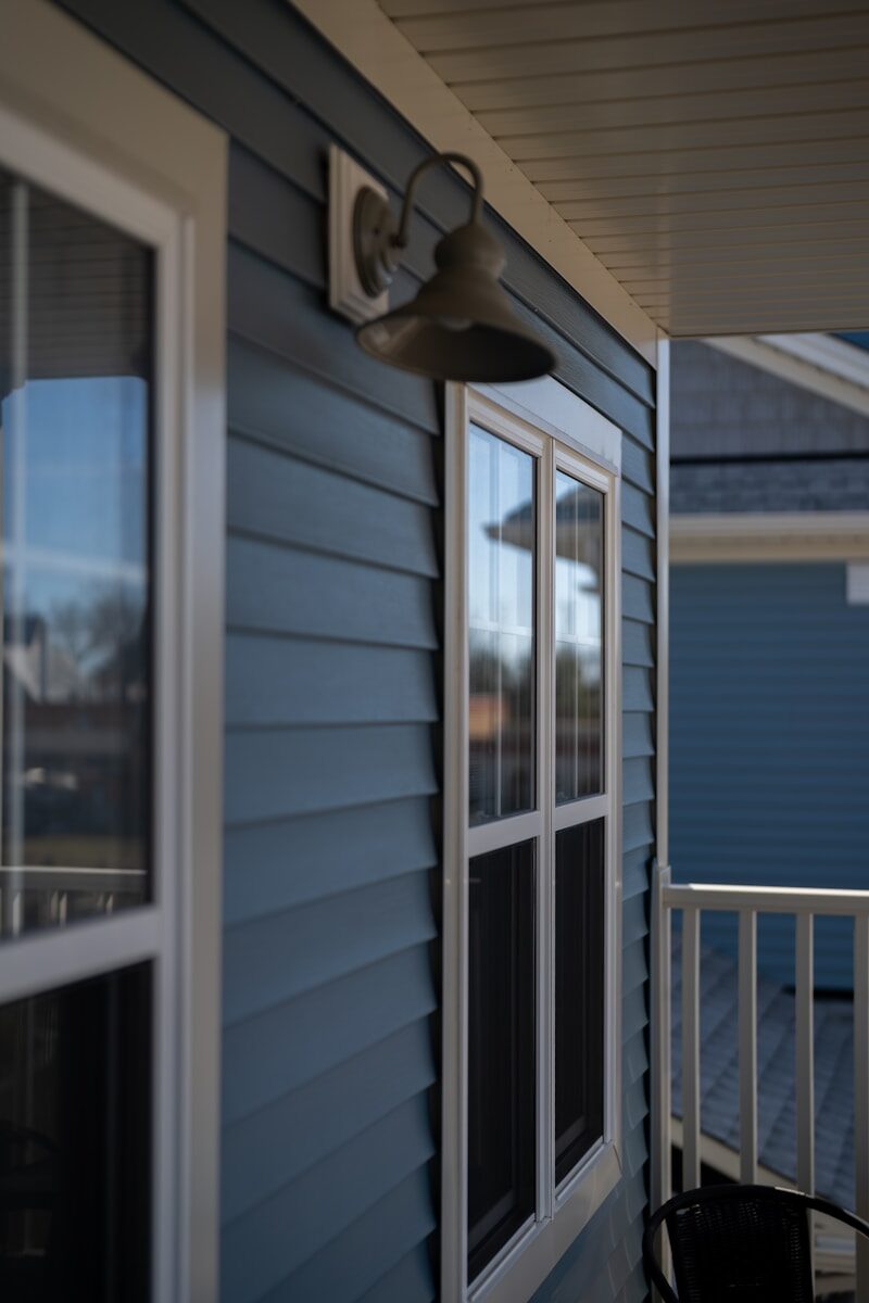 Blue siding house with white trim and outdoor light.