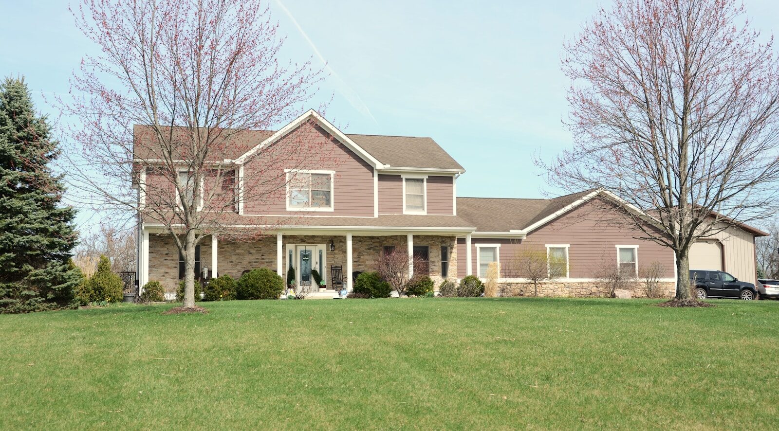 A large suburban house with a green lawn.